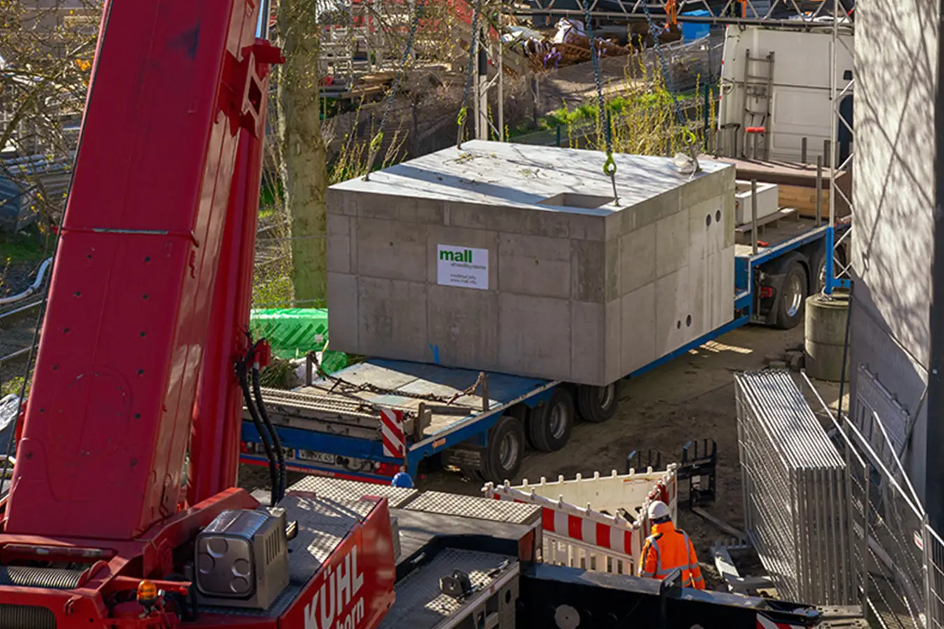 Vorgefertigtes Betonbauwerk auf einem Tieflader neben einem Autokran