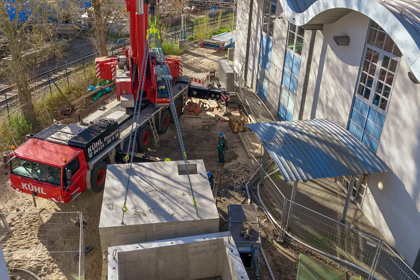 Autokran setzt ein Betonbauwerk auf einer Spezialtiefbau-Baustelle ein